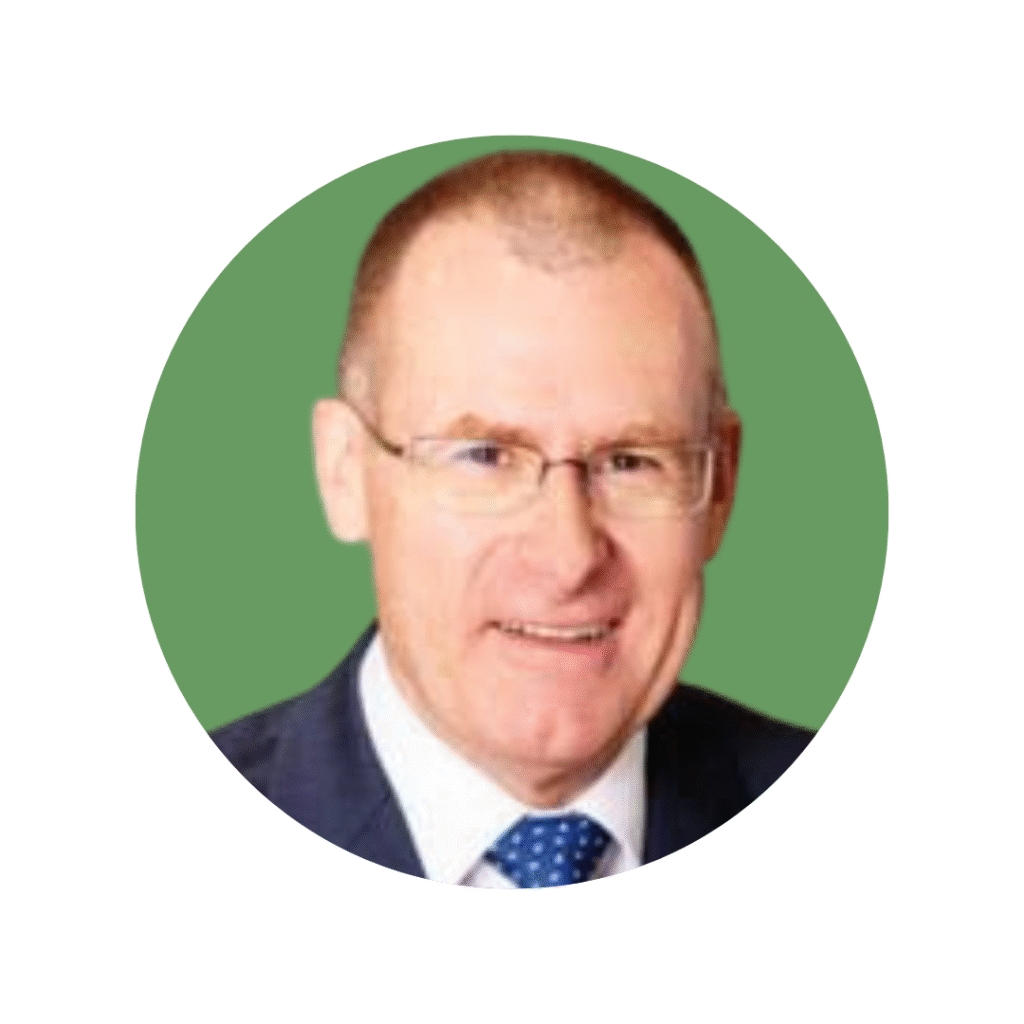Man with short hair and glasses in suit, shirt and tie, smiling at camera