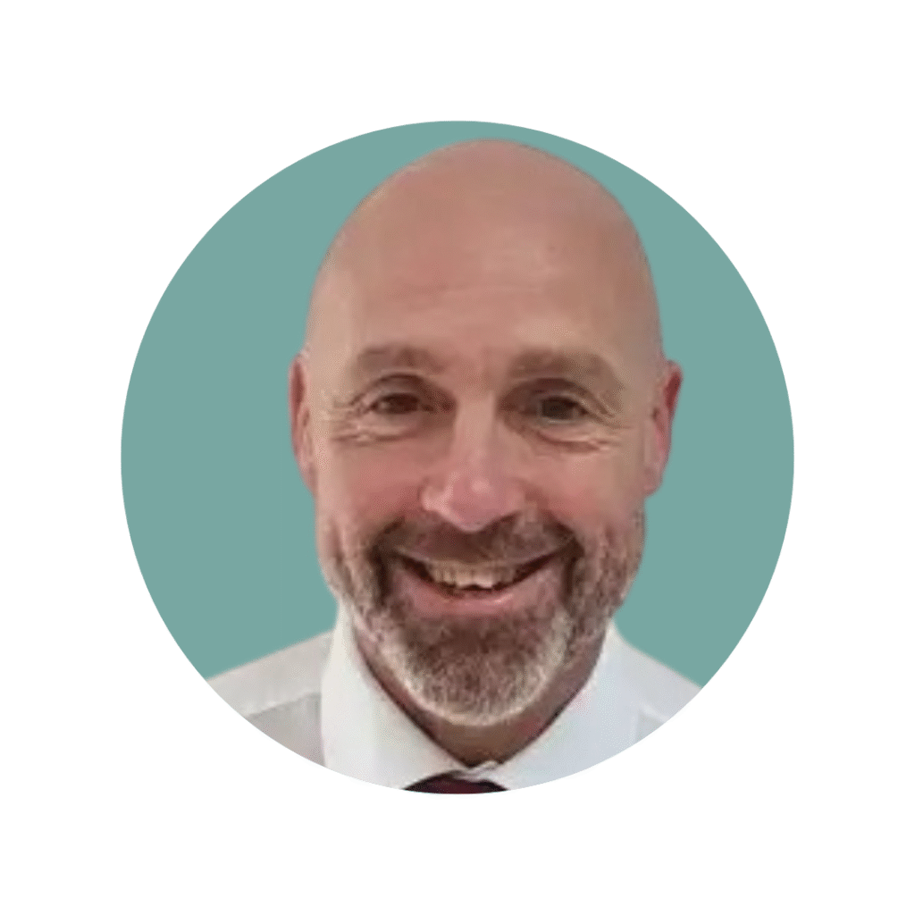 Man with beard and moustache smiling at camera wearing shirt and tie.