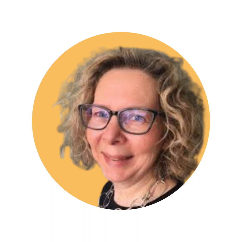 woman with blond wavy hair and dark glasses smiling at camera