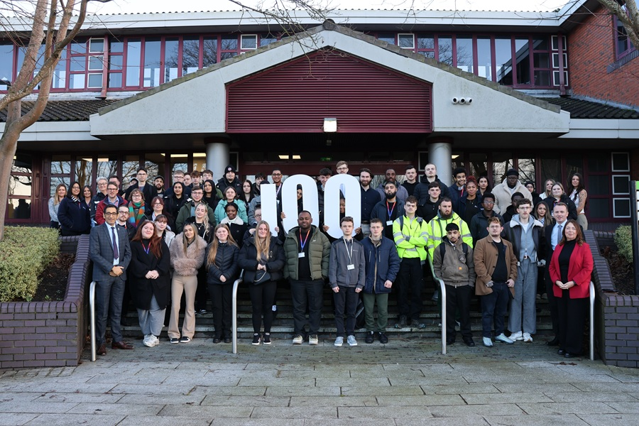 a group of apprentices are stood on the steps outside of Sandwell Council House. The second row are holding up numbers in white which show '100'