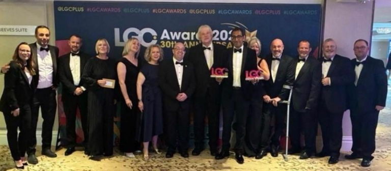 Leader, Chief Executive and staff from the Council at the awards stood in line holding two awards