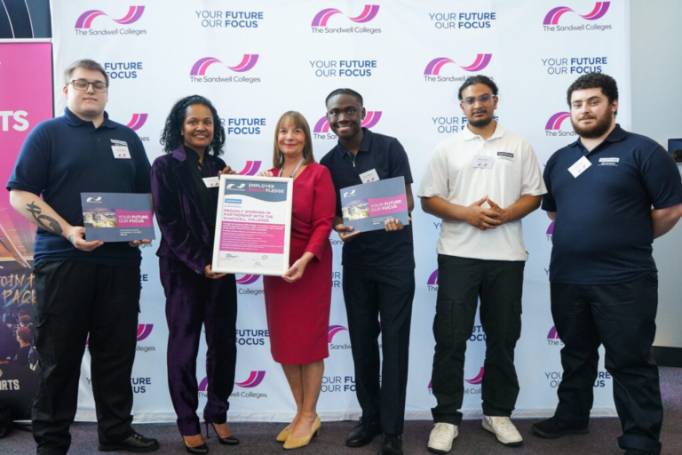 Lisa Capper stands with students and staff from hydraPower dynamics holding King's Award notice