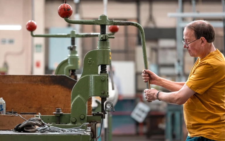 man stood at machine making bike saddle